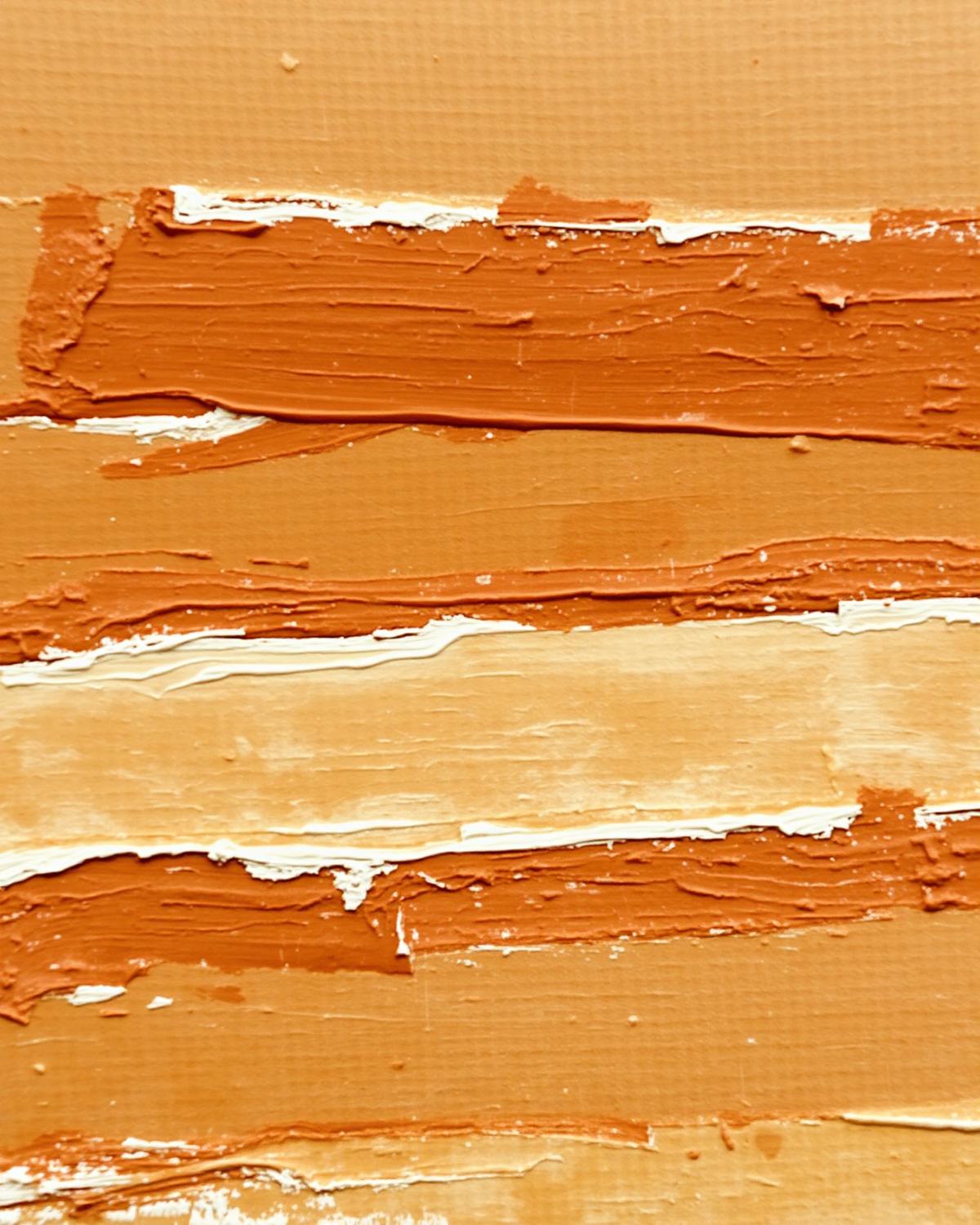 Close detail of warm ochre and ivory brushstrokes on a textured canvas
